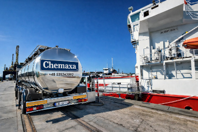 Tankwagen met Chemaxa-logo naast een schip in de haven